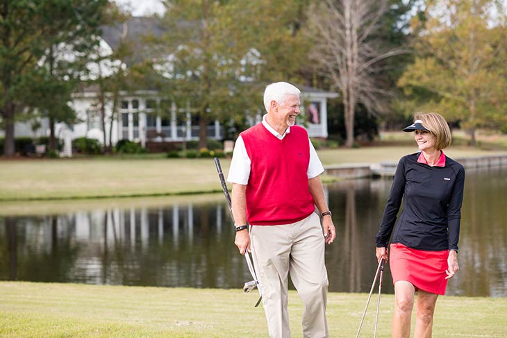 Photo of a man and woman laughing on a golf course
